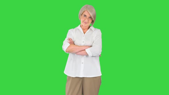 Elderly Woman Standing with Crossed Hands on a Green Screen Chroma Key