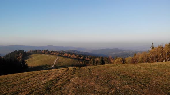 Flight over autumn mountains in the light of the setting sun.