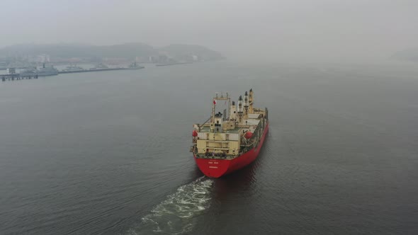 Aerial follow and flyover shot of an international cargo ship, empty barge with no shipments, sailin