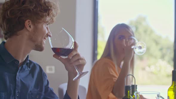 Young Man and Woman Drinking Red Wine During Homemade Lunch