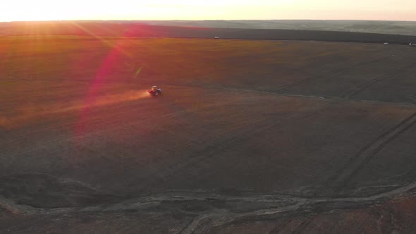 Tractor Spreading Artificial Fertilizers in Green Field