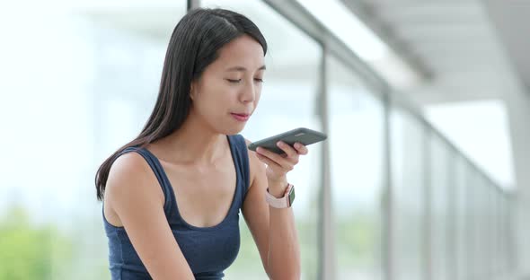 Woman Sending Audio Message on Cellphone in City