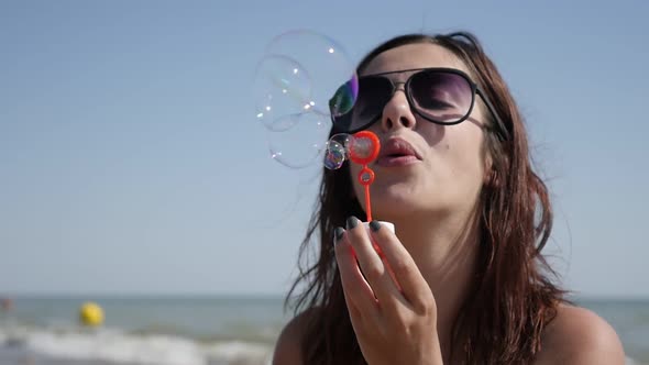 On ocean beach young Caucasian brunette blowing soap bubbles slow-mo  1920X1080 HD video - Happy fem