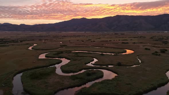 Winding river cuts through the land in Wyoming during sunrise