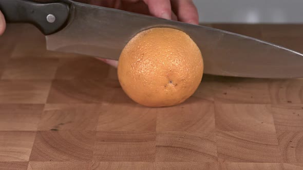 700365 Orange being Cut with a Knife, Slow Motion