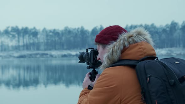 Adventure Photographer Takes Pictures of a Lake in the Winter Forest