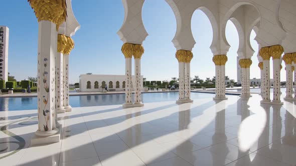 Revealing the richely decorated golden white hallway of the Grand Mosque in Abu Dhabi