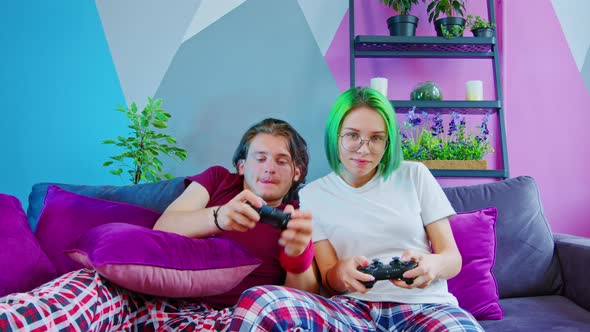 A Couple in Pajamas Playing a Game Console