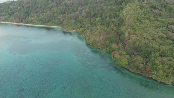 Aerial: flying over tropical Hatta island sand beach Banda Islands Indonesia