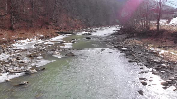 Flying Over Wild Mountain River Flowing with Stone Boulders and Rapids