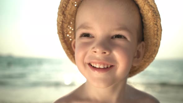 Portrait Cute Boy in a Straw Hat on the Beach