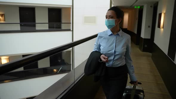 Adult Female Wearing Face Mask in Hotel Corridor