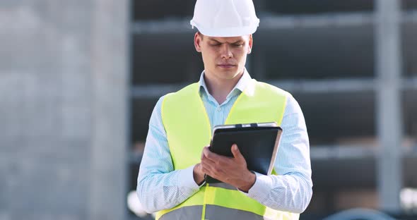 Professional Architecture Inspector Working with Digital Tablet at Construction Site, Tracking Shot