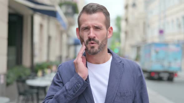 Outdoor Portrait of Man Having Toothache Cavity