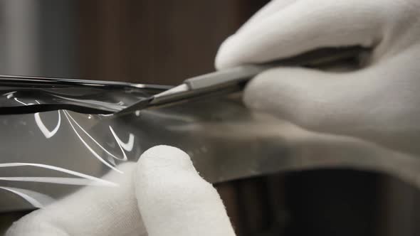 Worker Trimming with Cutter Remains of a Protective Film