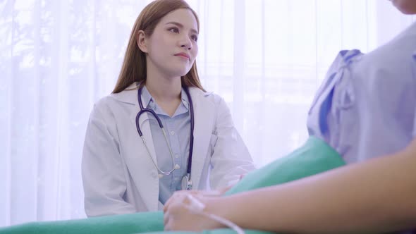 Young Asian doctor woman talking and holding hand for women patient in sick bed.