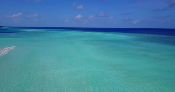 Tropical flying travel shot of a white sandy paradise beach and aqua turquoise water background in c