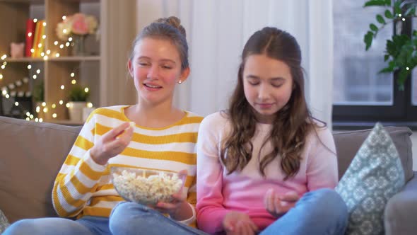 Teenage Girls Eating Popcorn at Home
