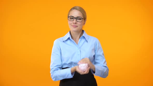 Attractive Young Woman Shaking Piggybank, Bank Account, Financial Fund, Savings