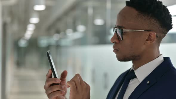 Portrait of Attractive African Businessman Using Smartphone 