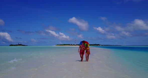 Fun couple on honeymoon vacation live the dream on beach on white sand 4K background