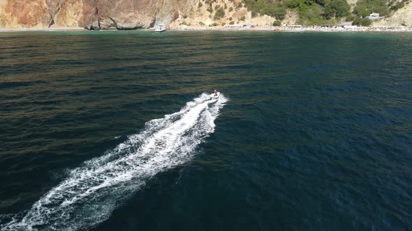 Happy People Swim on Air Mattress Behind a High Speed Water Bike