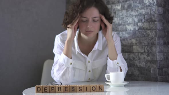 Depression Is Assembled From Wooden Cubes On Table. Tired, Depressed, Exhausted Business Woman