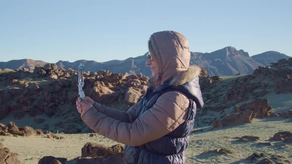 Pretty Girl Vlogger Takes Selfies Against a Martian Landscape in Cold and Windy Weather