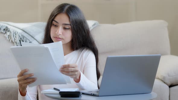 Focused Young Freelancer Housewife Arabian Woman Girl Holds Papers Utility Bills Makes Remote