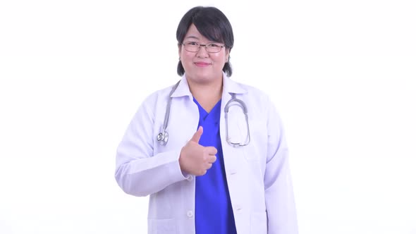 Happy Overweight Asian Woman Doctor Giving Thumbs Up