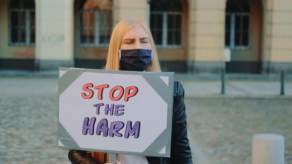 Blonde Woman in Protective Mask Protesting To Stop Harm By Holding Steamer