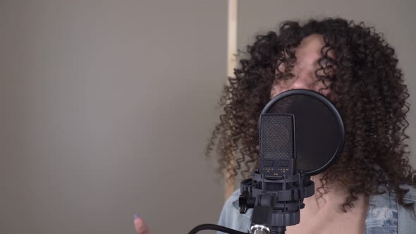 Portrait of a Young Beautiful Woman Singer in a Recording Studio