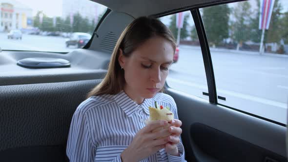 Cute Brunette Eat Sandwich in the Taxi Car