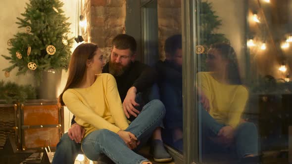 Relaxed Chatting Couple Sitting on Windowsill