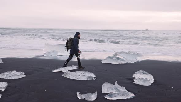 Photographer Walking Along Diamond Beach in Iceland