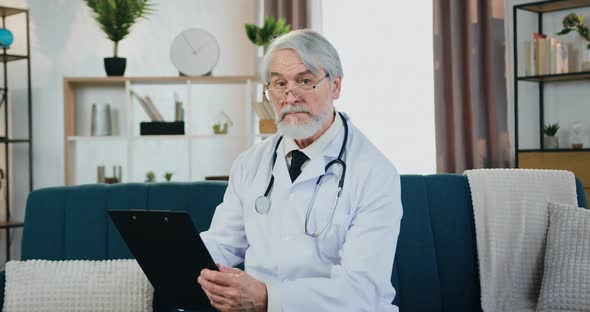 Doctor in Glasses which Posing on Camera in Beautifully Decorated Room During Working