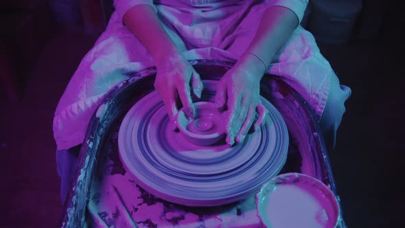 Young Woman Potter Working with a Wet Clay in Neon Lighting