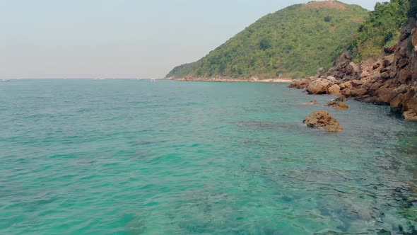 Low Motion Over Perfect Blue Ocean Water By Green Island