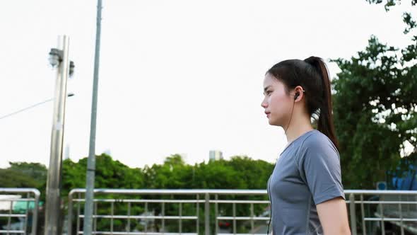 follow-up shot of side views young Asian woman athlete walking after a run.