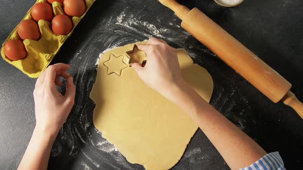 Hands Cutting Dough with Star Shaped Cutter