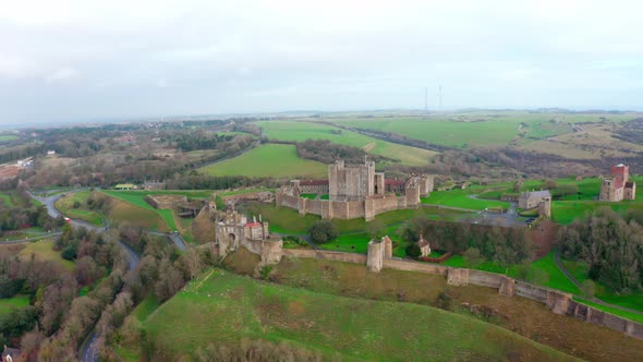 circling aerial shot around dover castle with white cliffs in background