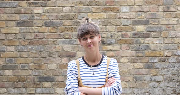 Portrait of smiling woman in front of brick wall