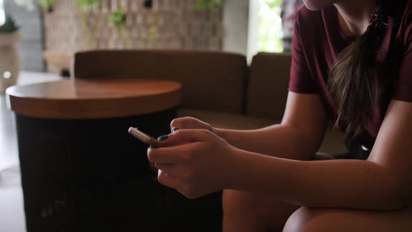 A Young Girl Waiting for a Hotel Room Writes in a Chat on a Mobile Phone