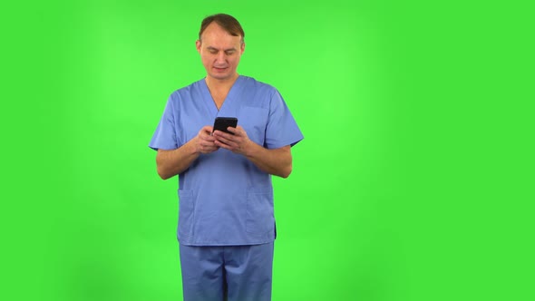 Medical Man Texting on Him Phone and Rejoice. Green Screen