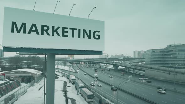 Billboard with MARKETING Text at Urban Highway in Winter