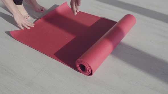 Young Woman Rolling Black Fitness or Yoga Mat Before or After Sport Practice, Working Out at Home in