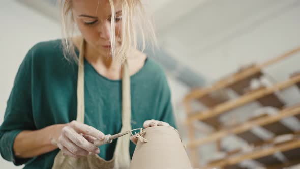 Woman Pooter Removing Extra Clay From Ceramic Pot Smoothing Out Crockery Item at Pottery Slow Motion