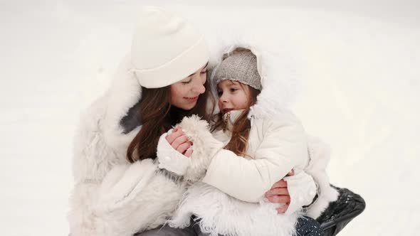 Mother Having Fun Sledding with Kids in Winter Forest