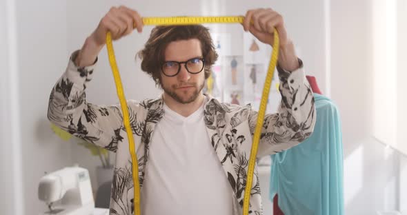 Smiling Fashion Designer Standing in Office Holding Measuring Tape