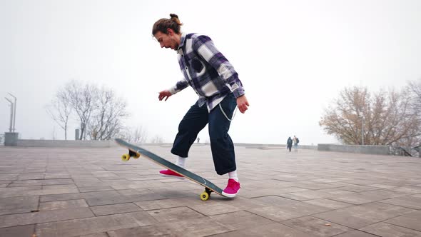 Guy is Riding a Longboard in the City Park